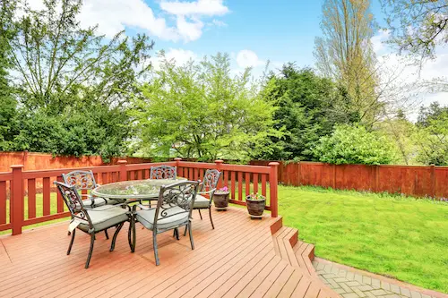 Large deck with dining space overlooking spacious well kept back yard.