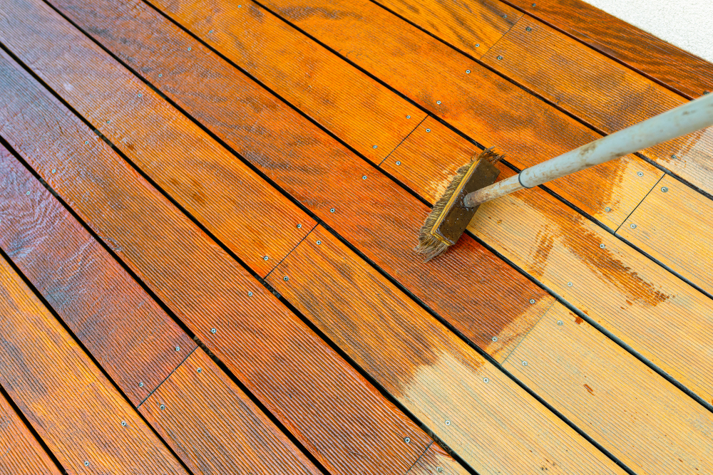 Home owner maintaining their wood deck